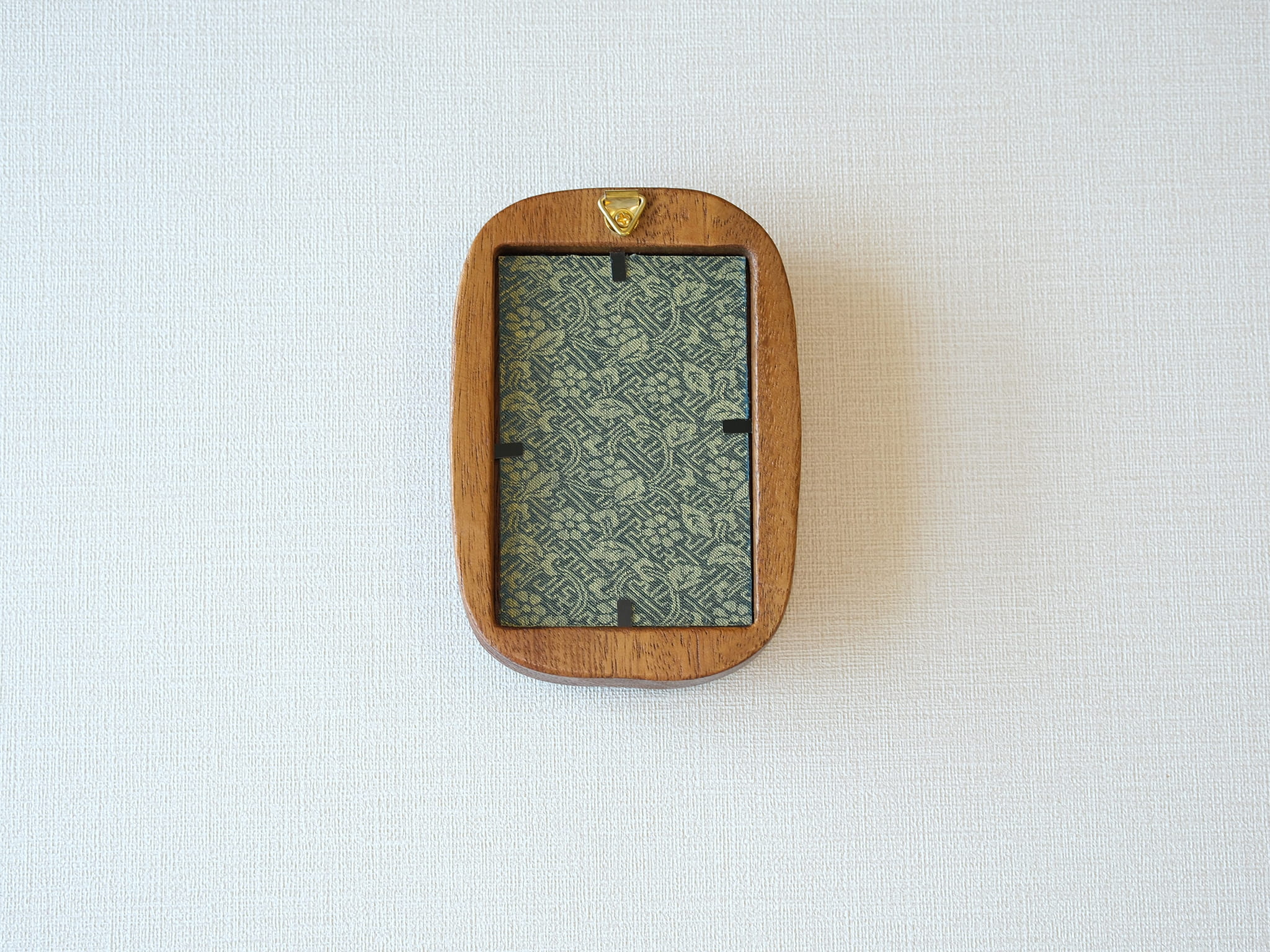 Rear view of the Rounded Rectangle solid wood frame, displaying the vertical grain of the back panel and the gold metal hanger for secure wall mounting.