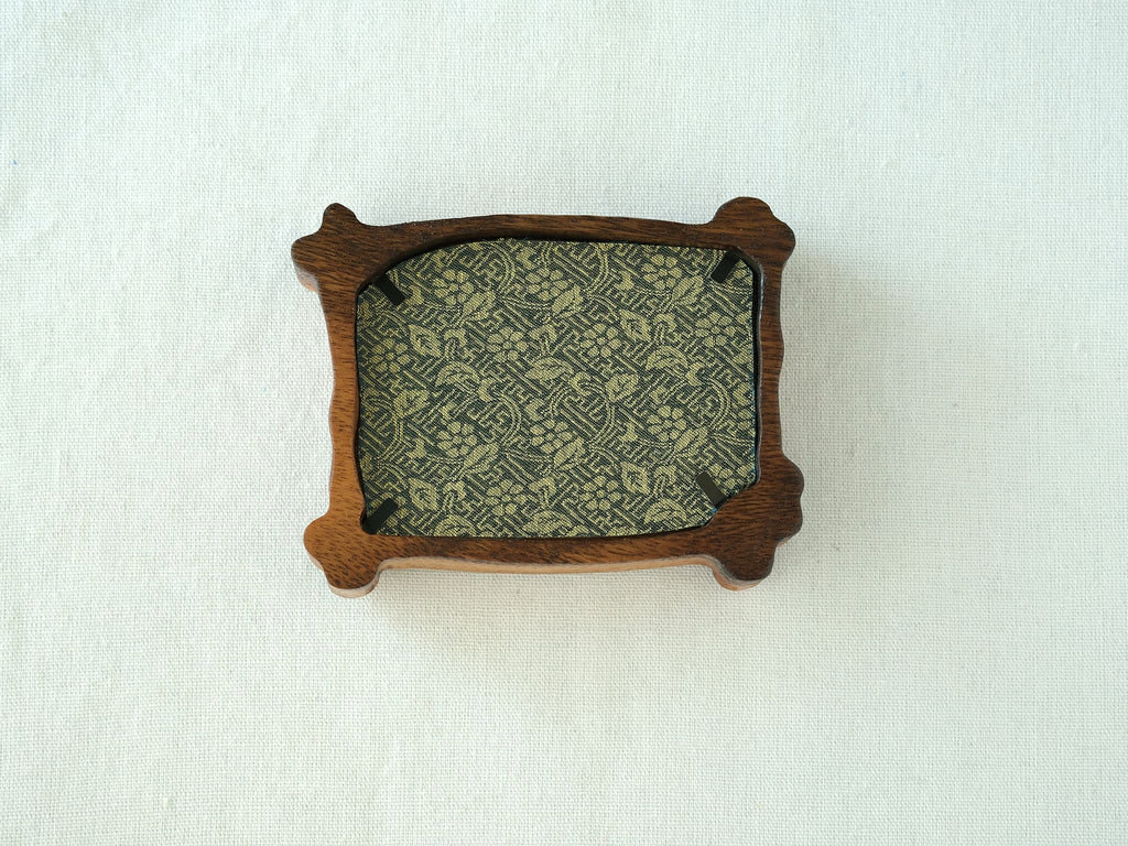 Rear view of the handcrafted nature-inspired wood frame featuring a green floral fabric backing, secure metal fasteners, and a golden hanging hook.