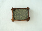 Rear view of the handcrafted nature-inspired wood frame featuring a green floral fabric backing, secure metal fasteners, and a golden hanging hook.