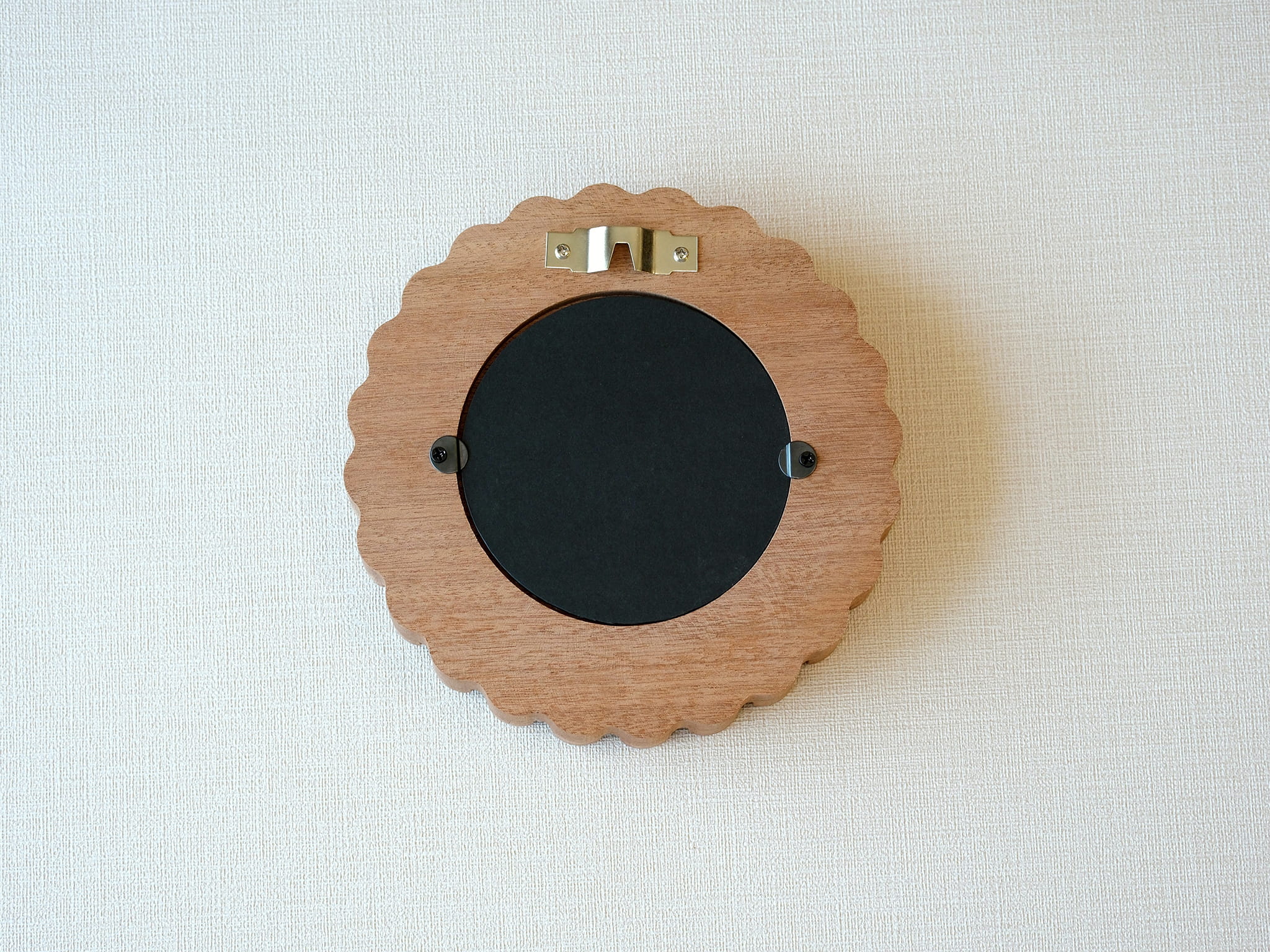Back view of the sunflower circular frame, showing the wall-mounting hook and easy-open tabs for swapping photos.