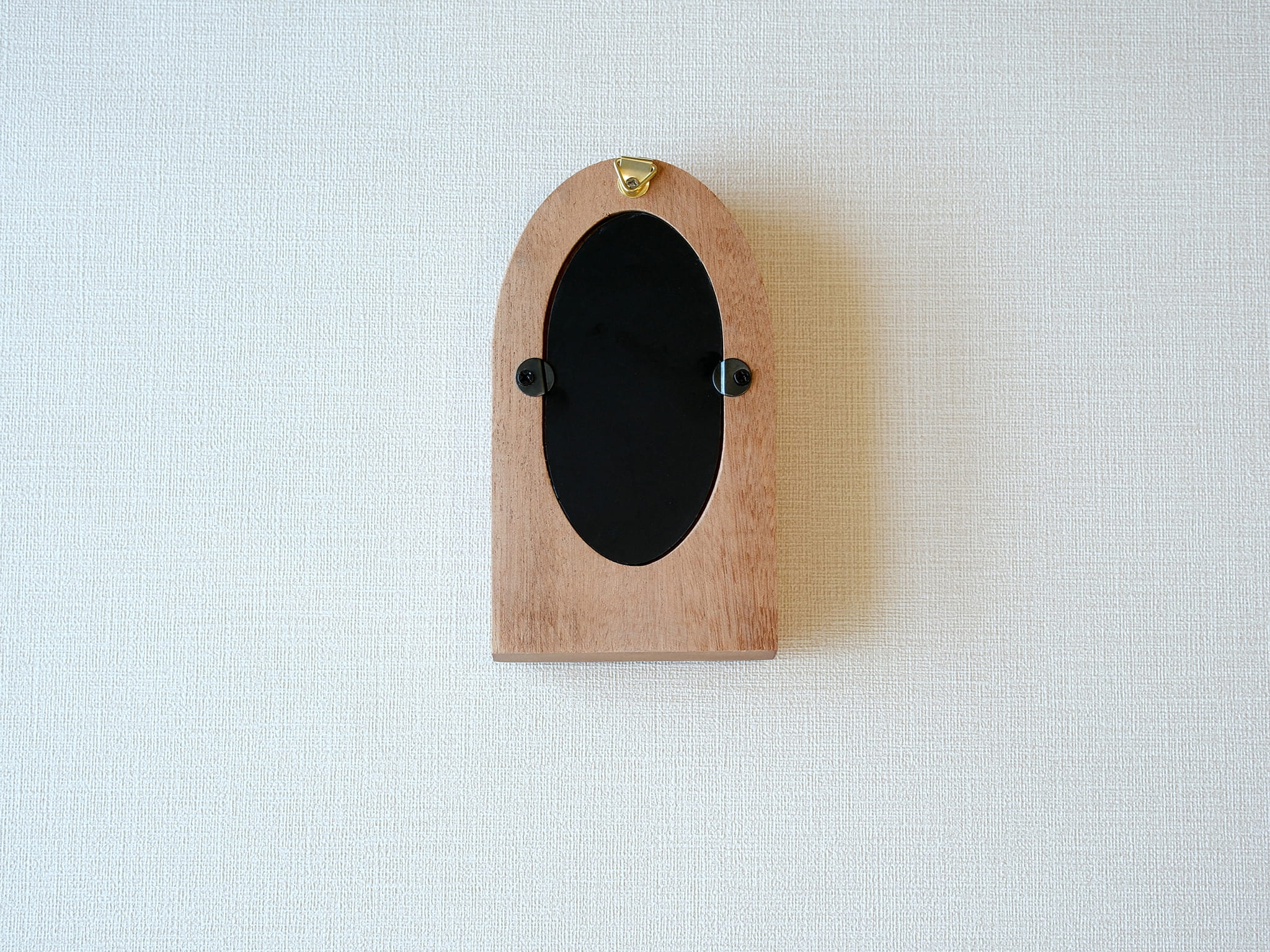 Back view of the arched wood frame, featuring a built-in metal hanger and secure turn-button hardware.