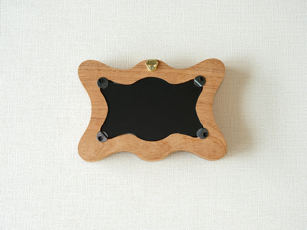Back view of the rippled wave frame, showing the wall hanger and four secure swivel tabs for easy art replacement.