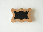 Back view of the rippled wave frame, showing the wall hanger and four secure swivel tabs for easy art replacement.
