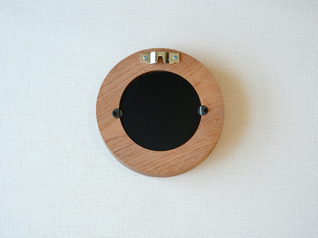 Back view of the round flower frame, showing the sturdy wood finish, three swivel tabs, and integrated wall hanger.