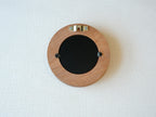 Back view of the round flower frame, showing the sturdy wood finish, three swivel tabs, and integrated wall hanger.