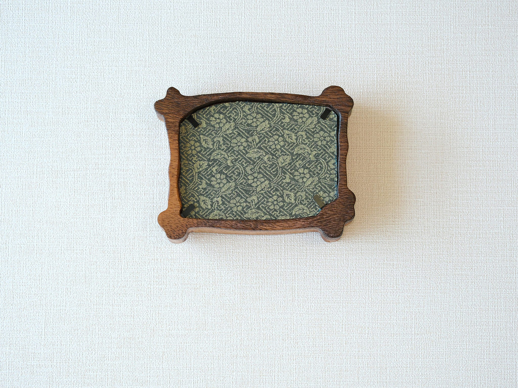 Rear view of the handcrafted nature-inspired wood frame featuring a green floral fabric backing, secure metal fasteners, and a golden hanging hook.