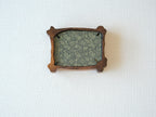 Rear view of the handcrafted nature-inspired wood frame featuring a green floral fabric backing, secure metal fasteners, and a golden hanging hook.
