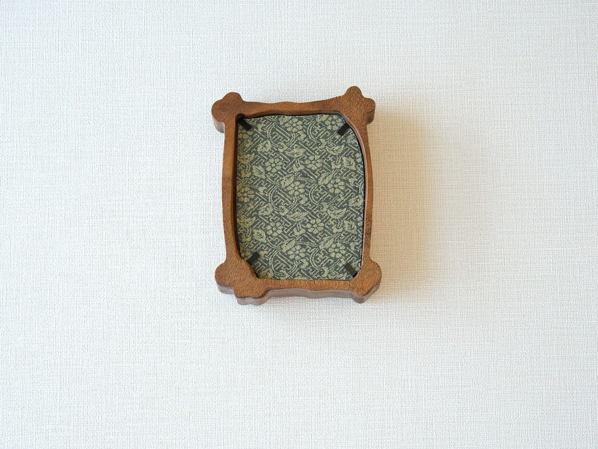 Back view of the organic solid wood frame, showing the elegant green patterned backing fabric and black metal retainer clips.