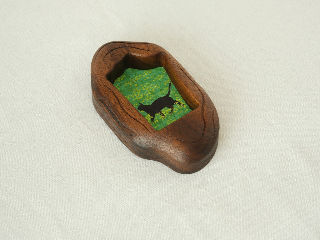 A perspective side view of the irregular organic wood frame, showcasing the rich, dark timber grain and the unique, fluid hand-carved edges.