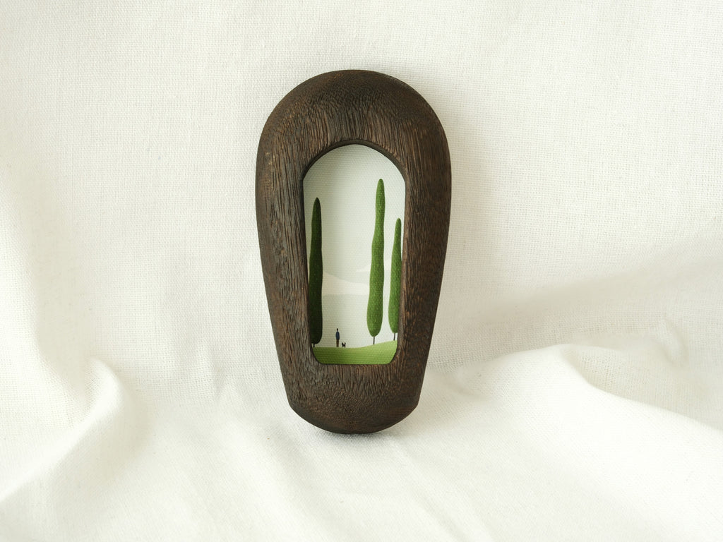 The black arched wood frame leaning against a white fabric backdrop, showcasing its modern minimalist design.