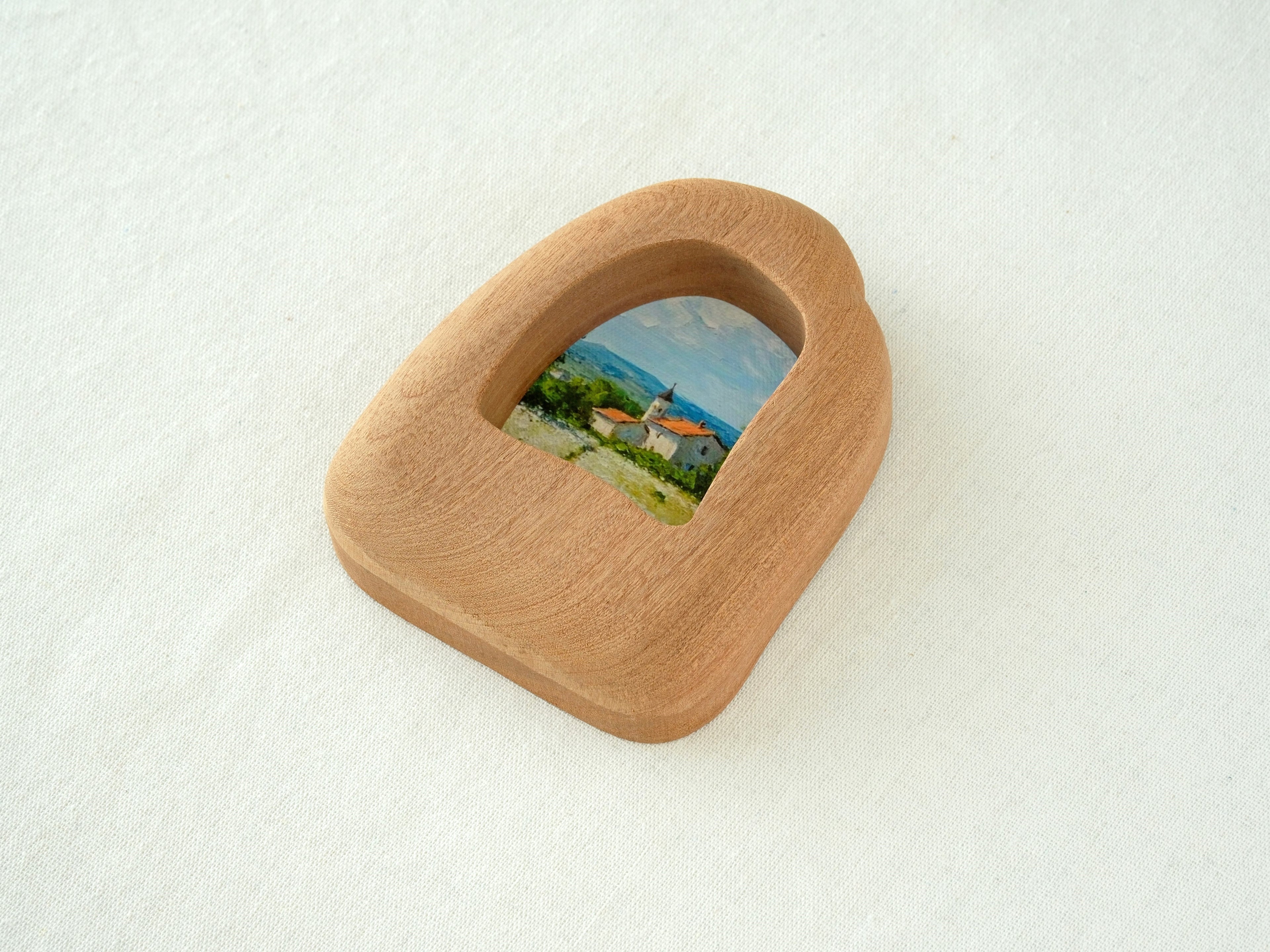 Side view of the house-shaped wood frame, highlighting its smooth, hand-carved organic edges and thick solid Sapele.