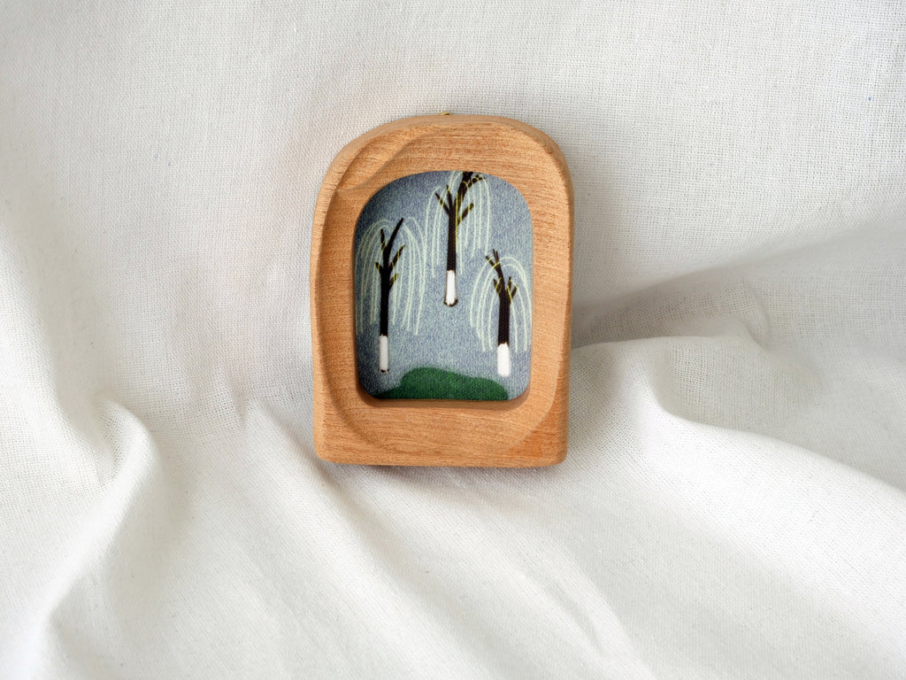 The soft arched wood frame leaning against a soft white draped background, creating a cozy and modern aesthetic.