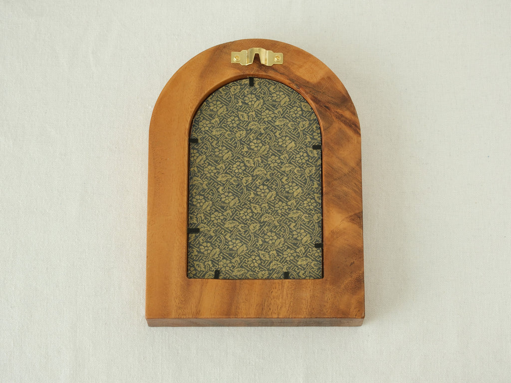 Rear view of the arched "Tuscany" solid wood frame, showing the integrated gold wall hanger and the elegant blue and gold floral textile backing that protects the artwork.