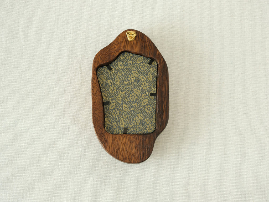 Rear view of the irregular organic solid wood frame, showing the integrated gold wall hanger and the patterned fabric backing that secures the artwork.