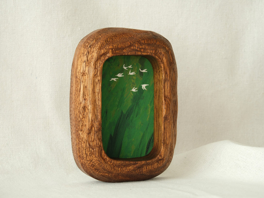 A vertical side-angled view of the Rounded Rectangle wood frame standing upright, highlighting the hand-carved rounded edges and the deep, sculptural quality of the solid timber.