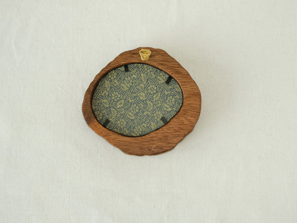 Rear view of the lake-shaped organic solid wood frame, revealing the uniquely patterned blue and gold textile backing and the integrated gold wall hanger.