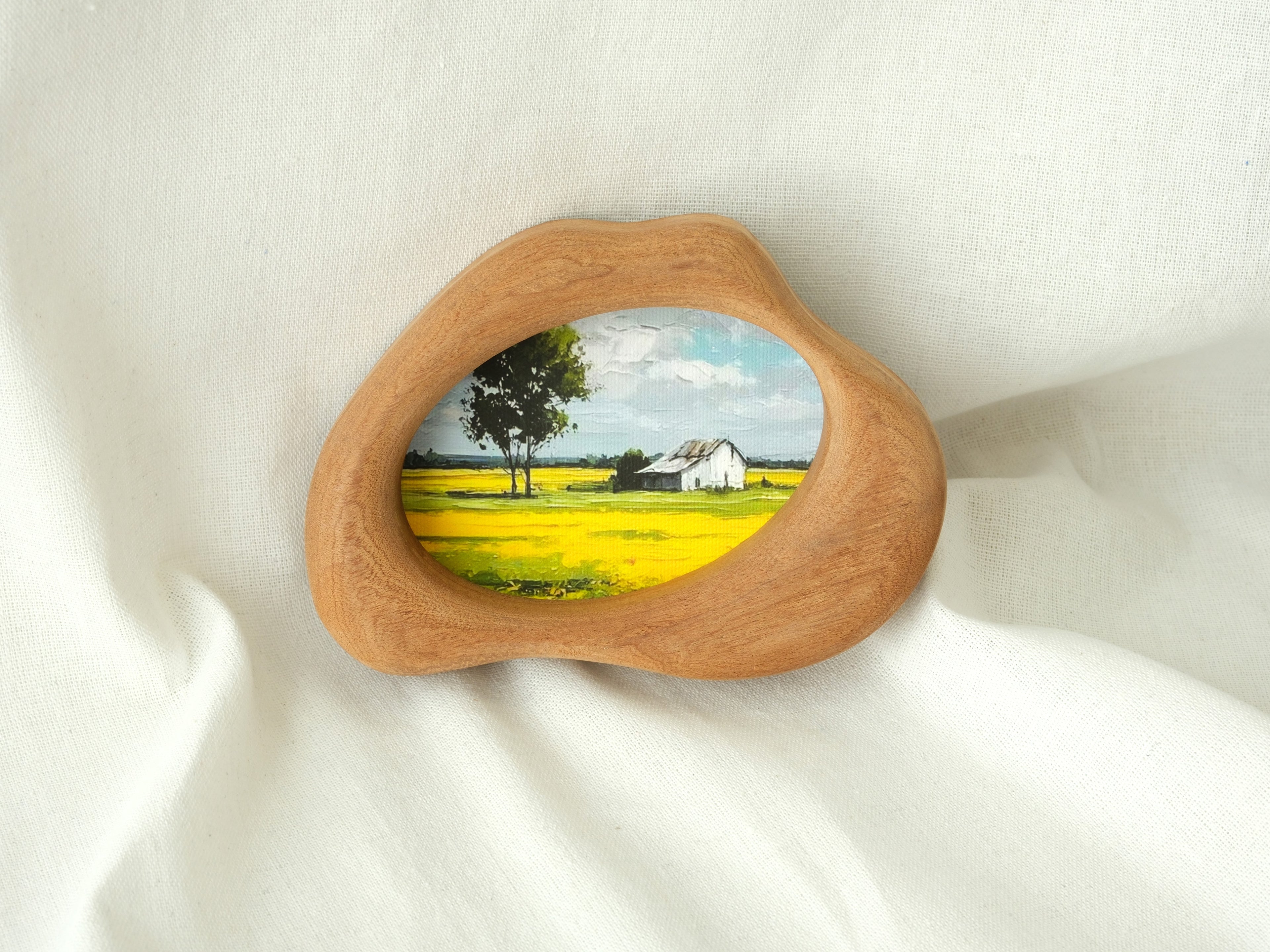 Cloud-shaped wood art frame leaning against a wall, showcasing its decorative, artistic presence in a home setting.