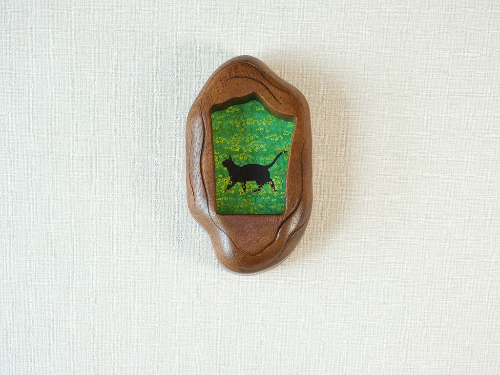 Front view of the Irregular Organic handmade solid wood art frame, featuring a charming illustration of a black cat walking through a field of yellow flowers.