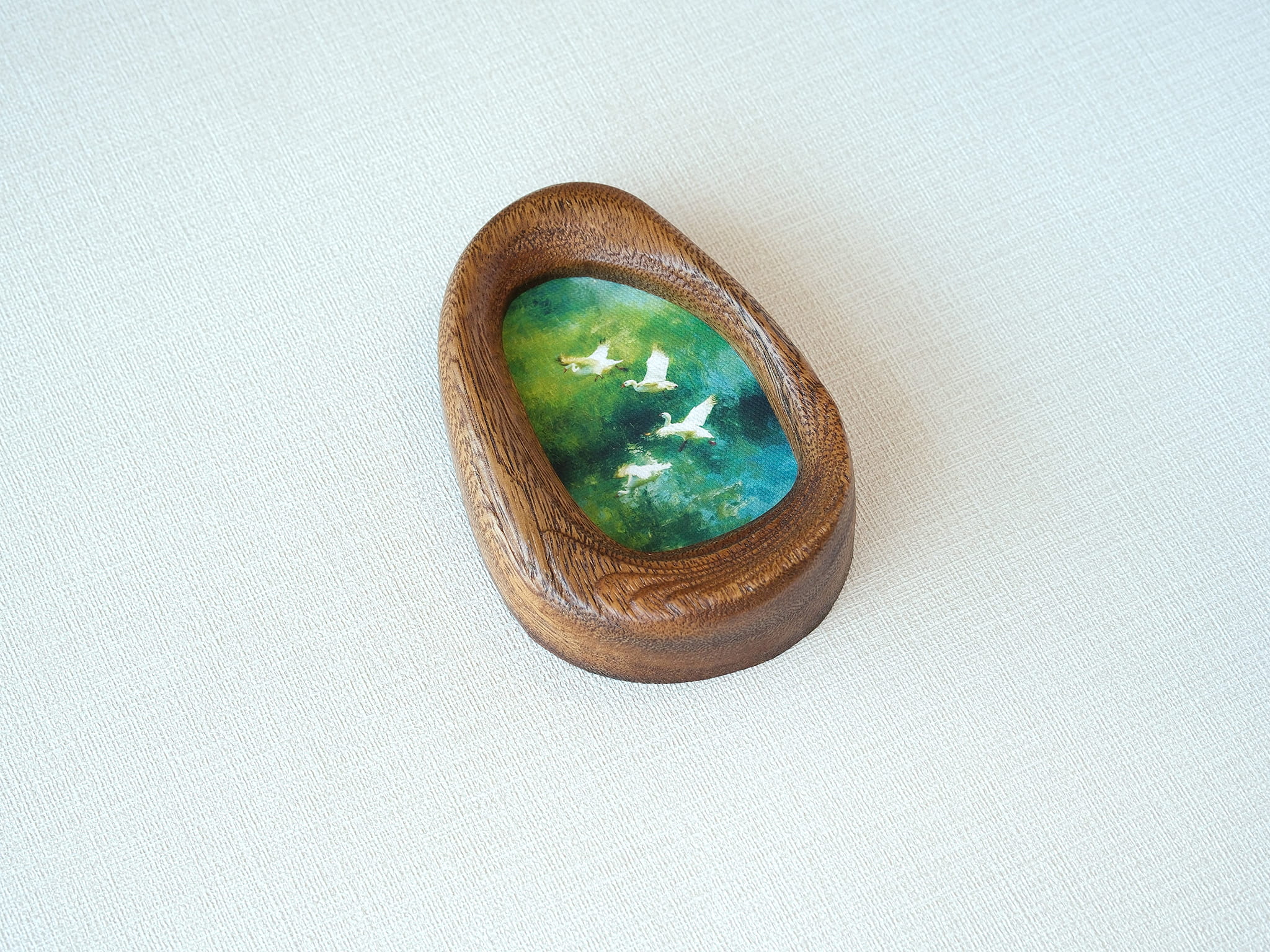 Angled view of the waterdrop-shaped solid wood frame, highlighting the natural grain patterns and the elegant curves of the hand-carved pebble silhouette.