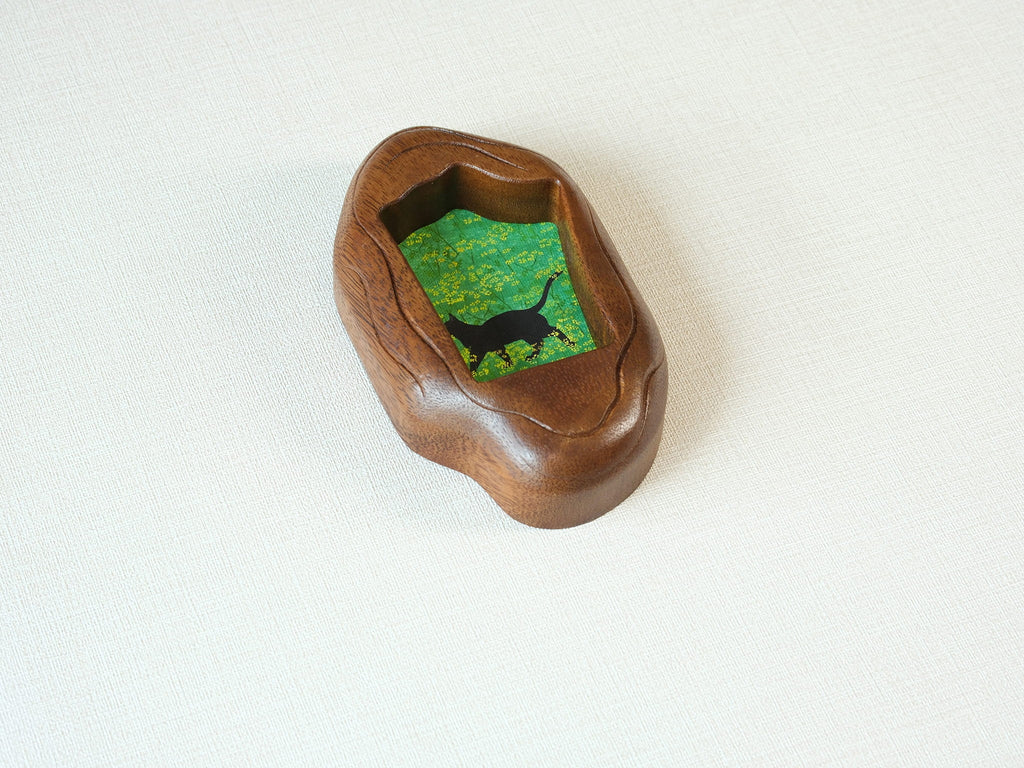 A perspective side view of the irregular organic wood frame, showcasing the rich, dark timber grain and the unique, fluid hand-carved edges.