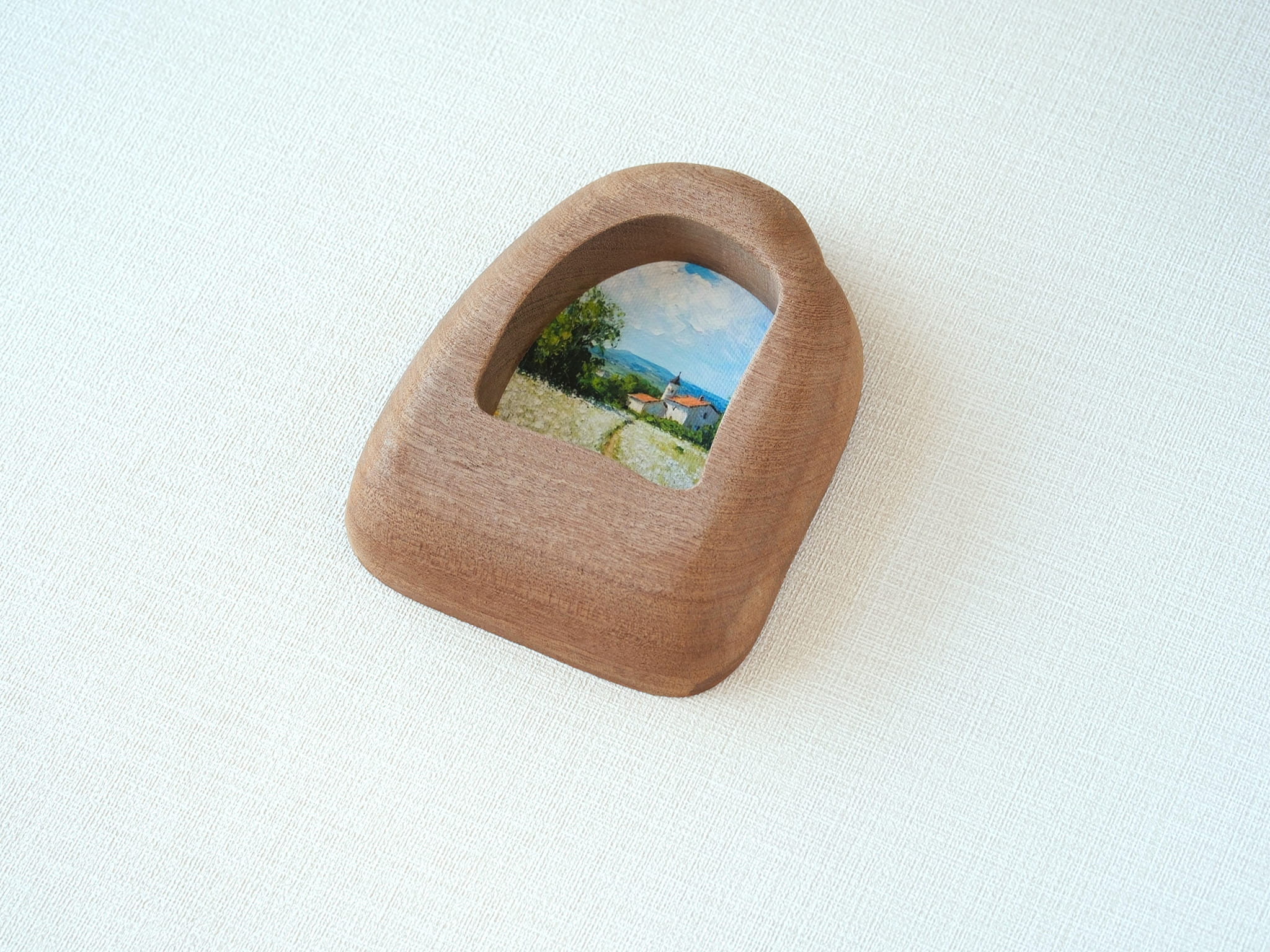 Side view of the house-shaped wood frame, highlighting its smooth, hand-carved organic edges and thick solid Sapele.