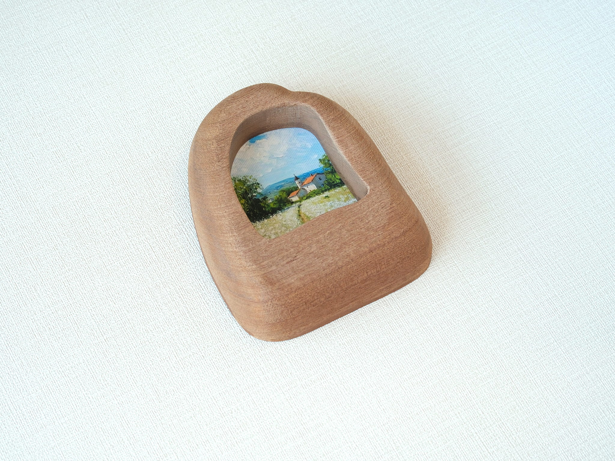 Alternative side angle of the house-shaped frame, showcasing the unique undulating texture and rich natural wood grain.