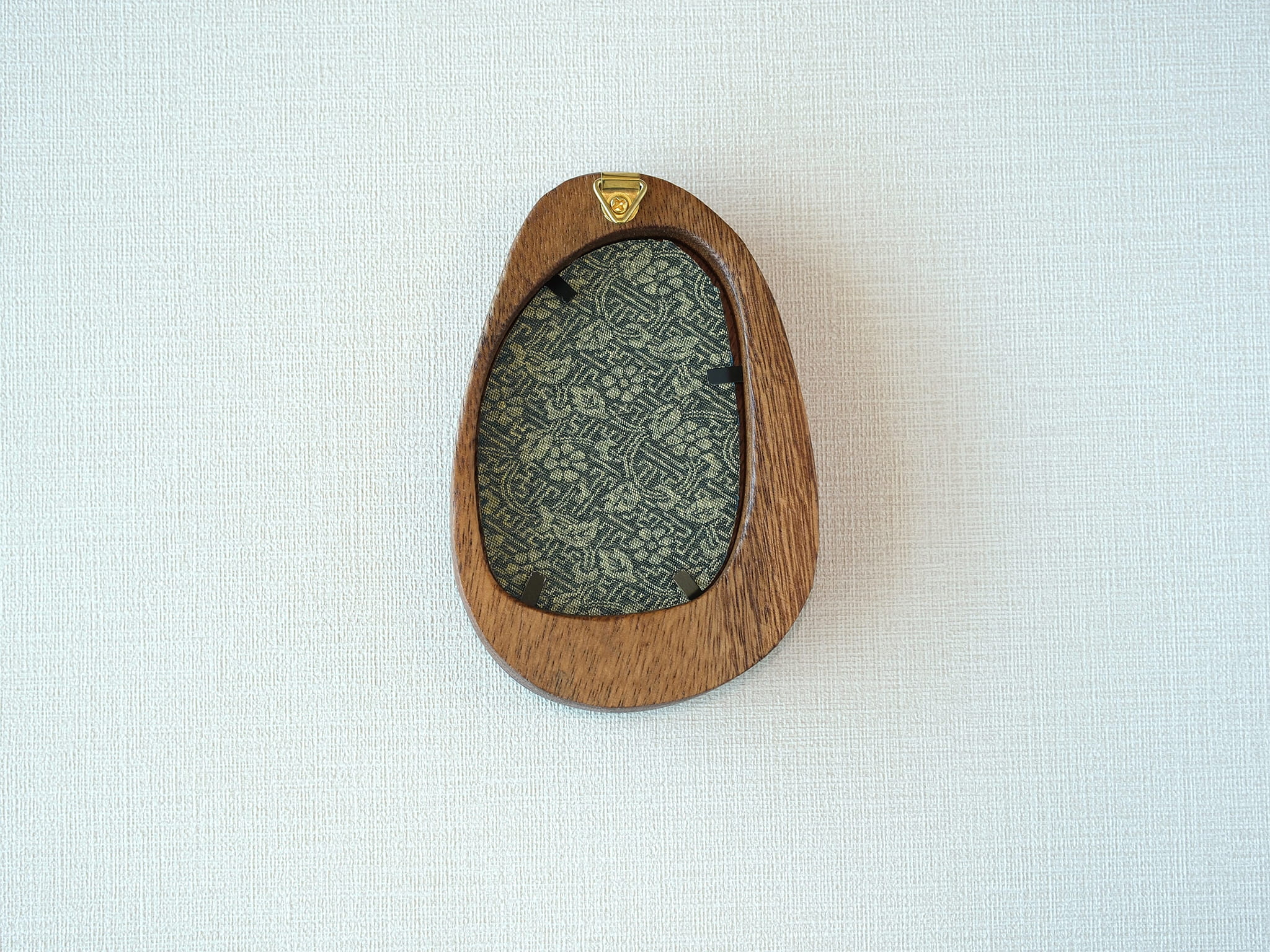 Rear view of the Waterdrop solid wood frame, showcasing its organic pebble-like profile and the integrated gold hanger for easy wall mounting.