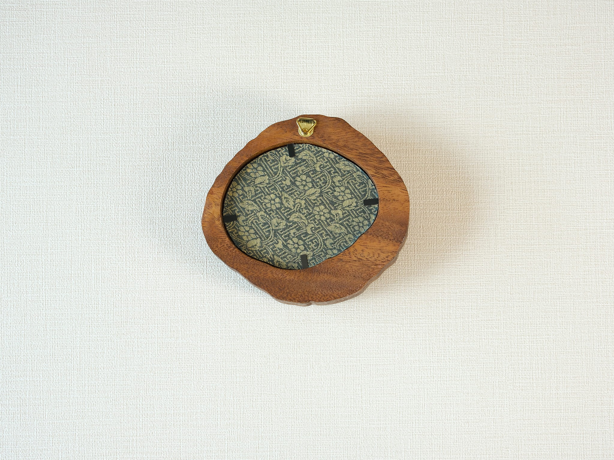 Rear view of the lake-shaped organic solid wood frame, revealing the uniquely patterned blue and gold textile backing and the integrated gold wall hanger.