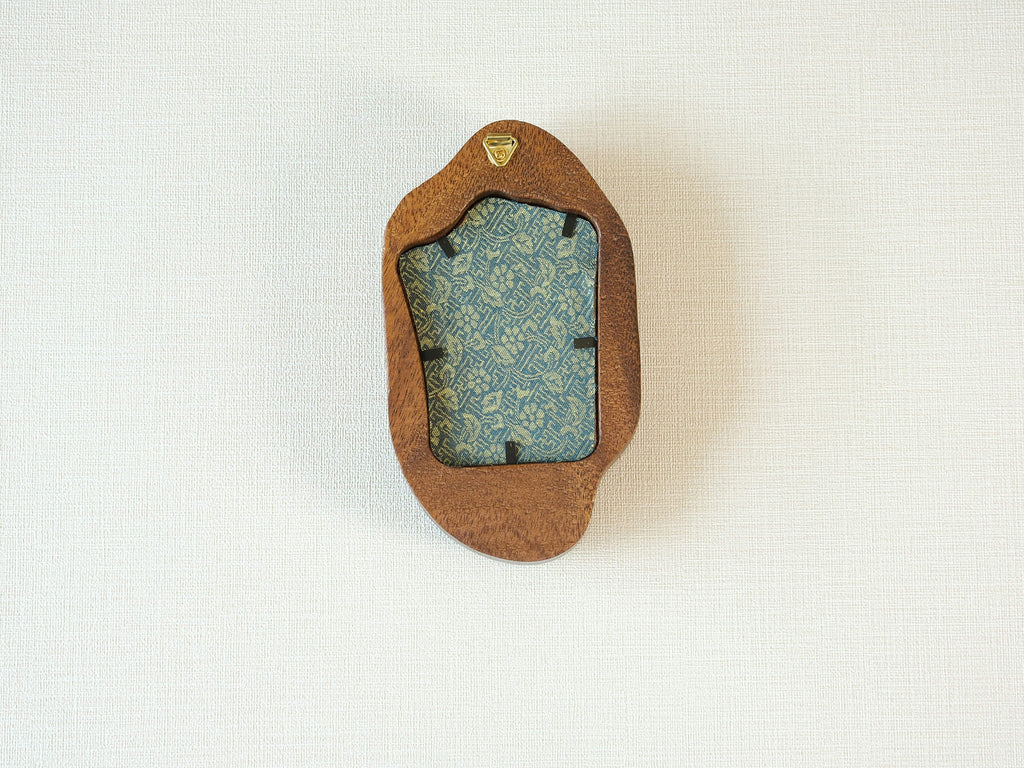 Rear view of the irregular organic solid wood frame, showing the integrated gold wall hanger and the patterned fabric backing that secures the artwork.