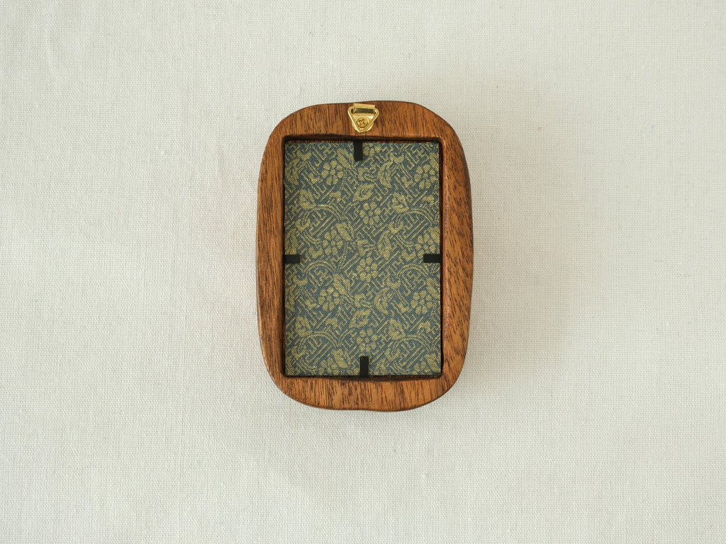 Rear view of the Rounded Rectangle solid wood frame, displaying the vertical grain of the back panel and the gold metal hanger for secure wall mounting.