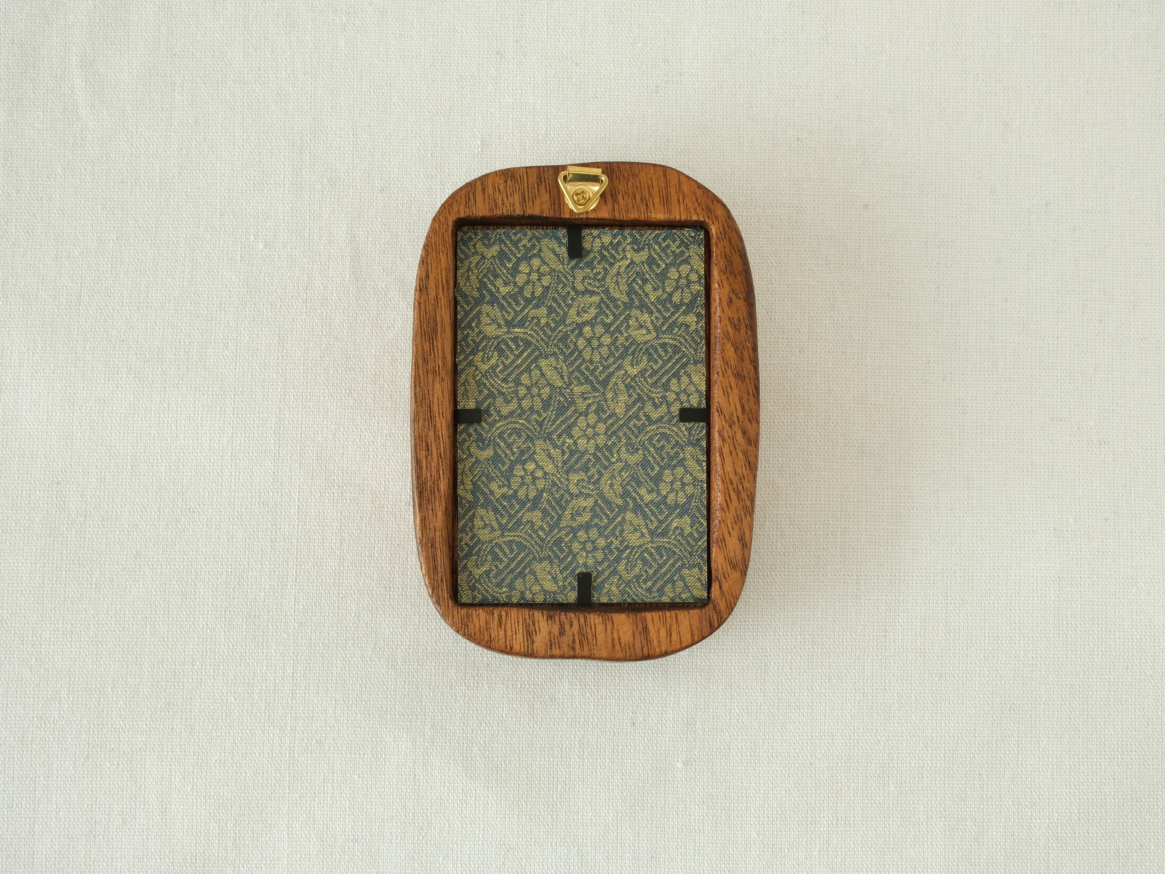 Rear view of the Rounded Rectangle solid wood frame, displaying the vertical grain of the back panel and the gold metal hanger for secure wall mounting.