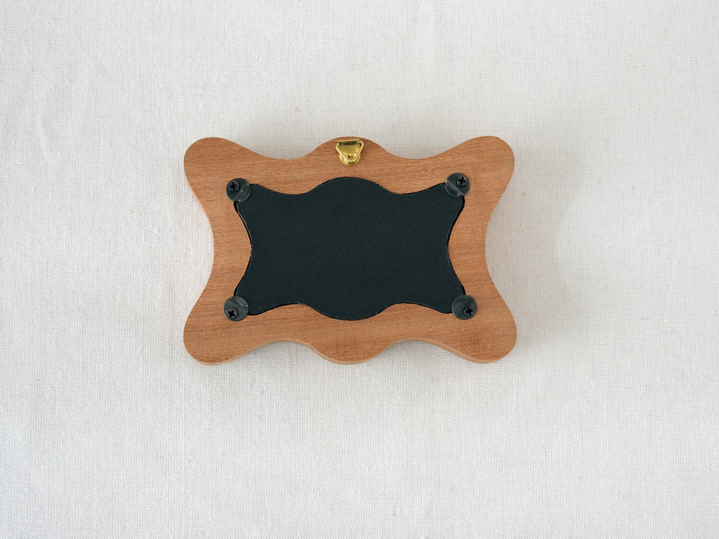 Back view of the rippled wave frame, showing the wall hanger and four secure swivel tabs for easy art replacement.
