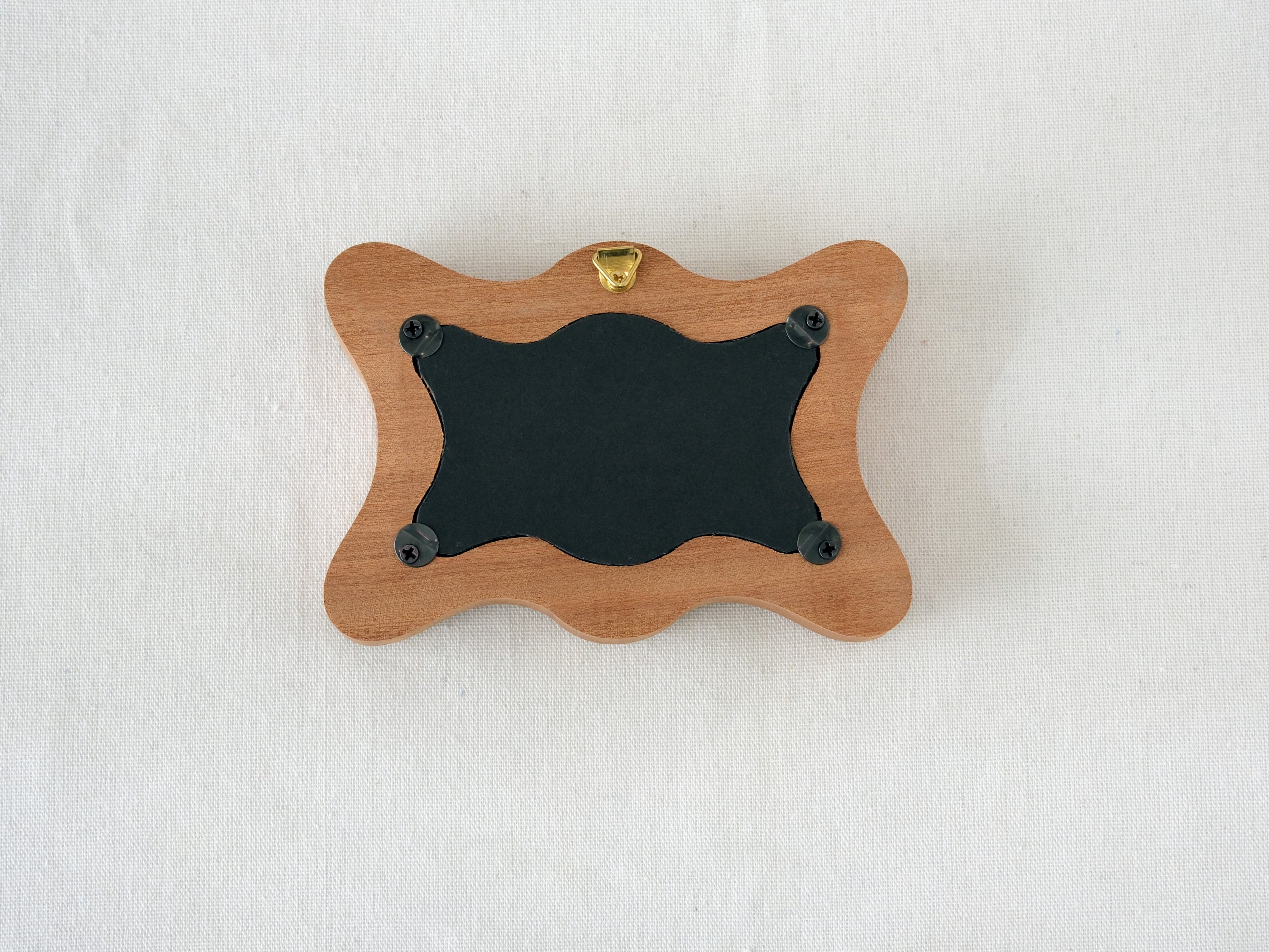 Back view of the rippled wave frame, showing the wall hanger and four secure swivel tabs for easy art replacement.