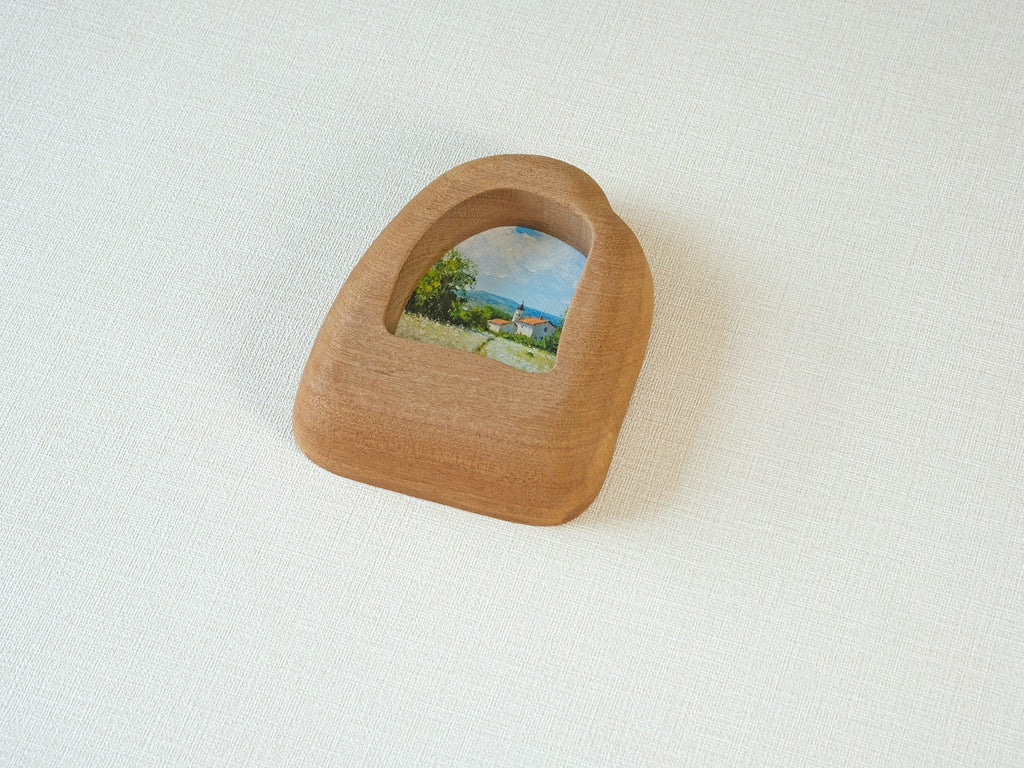 Side view of the house-shaped wood frame, highlighting its smooth, hand-carved organic edges and thick solid Sapele.