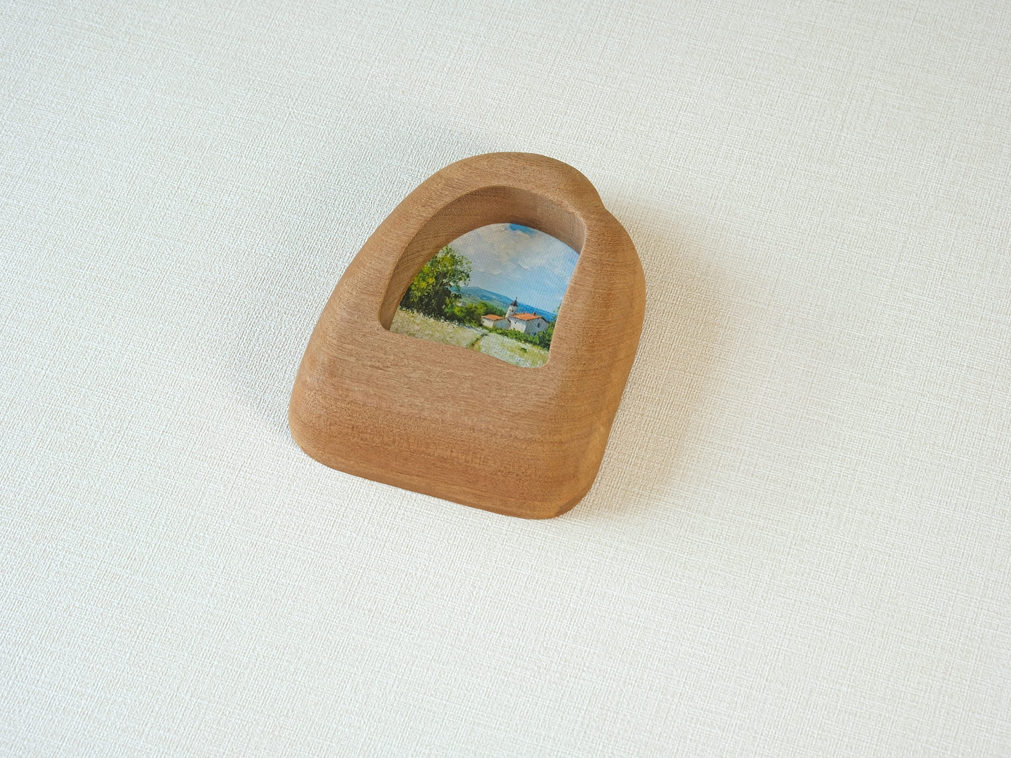 Side view of the house-shaped wood frame, highlighting its smooth, hand-carved organic edges and thick solid Sapele.