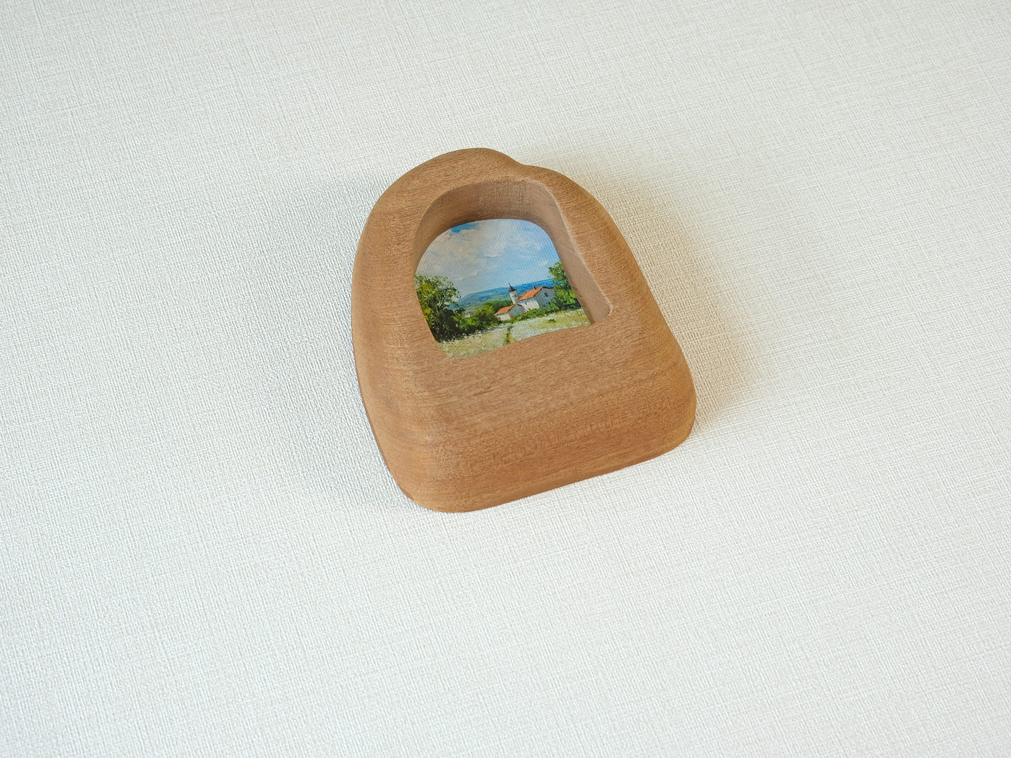 Alternative side angle of the house-shaped frame, showcasing the unique undulating texture and rich natural wood grain.