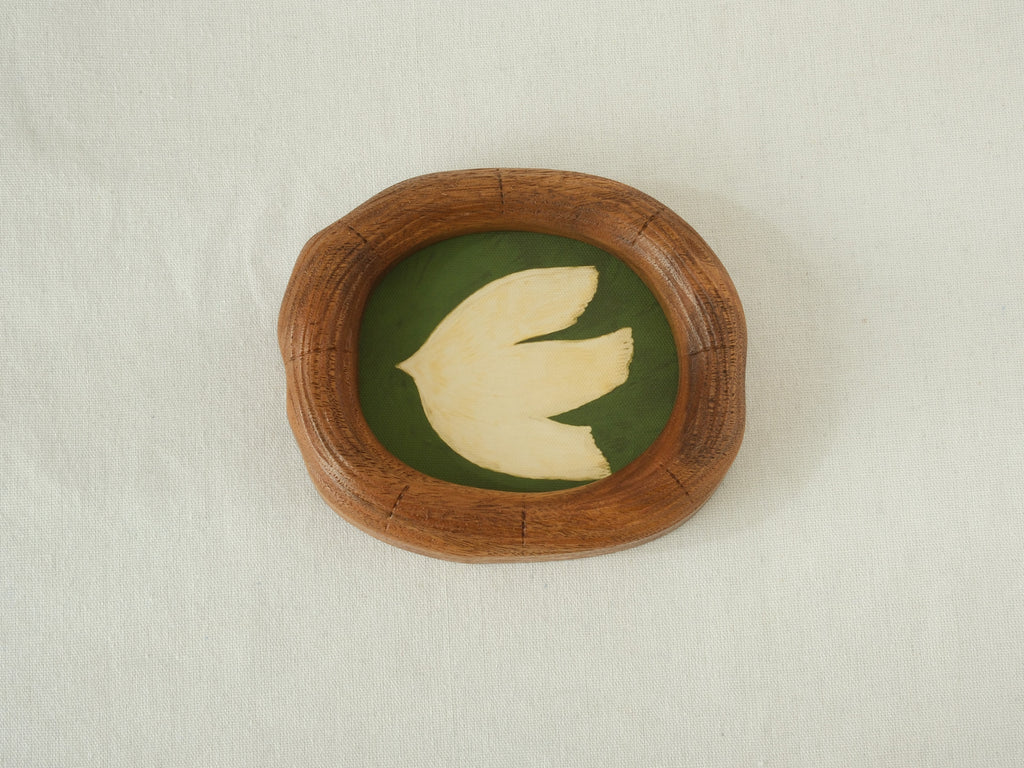 Front view of a Fomjia handcrafted organic-shaped wood frame featuring a minimalist cream dove illustration on a forest green canvas background.