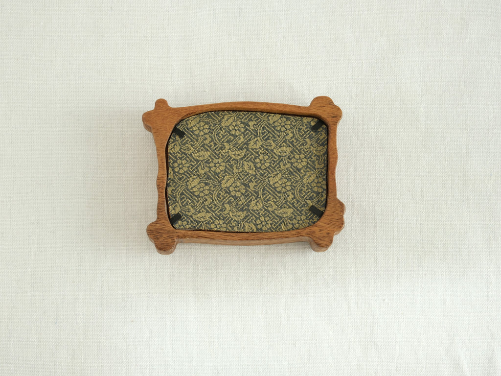 Rear view of the handcrafted nature-inspired wood frame featuring a green floral fabric backing, secure metal fasteners, and a golden hanging hook.