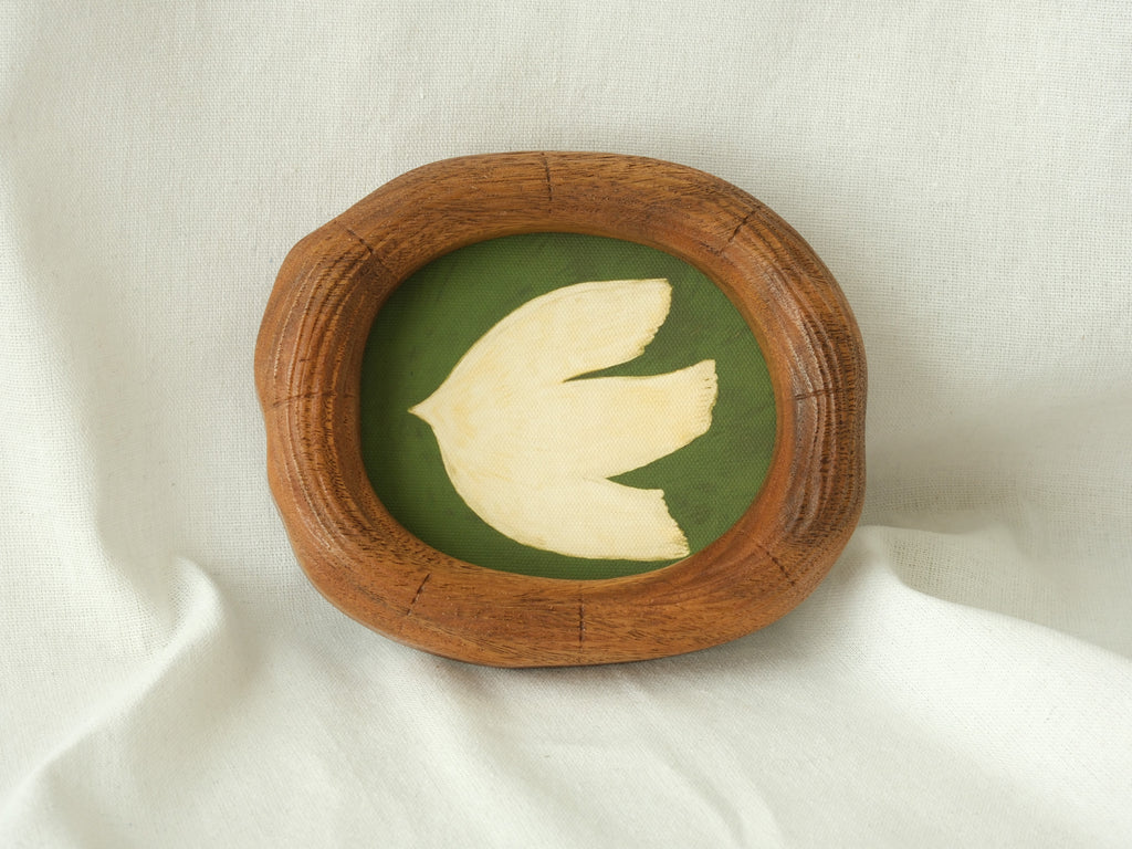 Close-up angled shot of an organic-shaped wood frame showing the rich hand-carved texture and smooth finish of the natural wood grain.