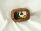 Aesthetic display of a walnut wood art frame on white linen, showing the top metal hanger for wall mounting.